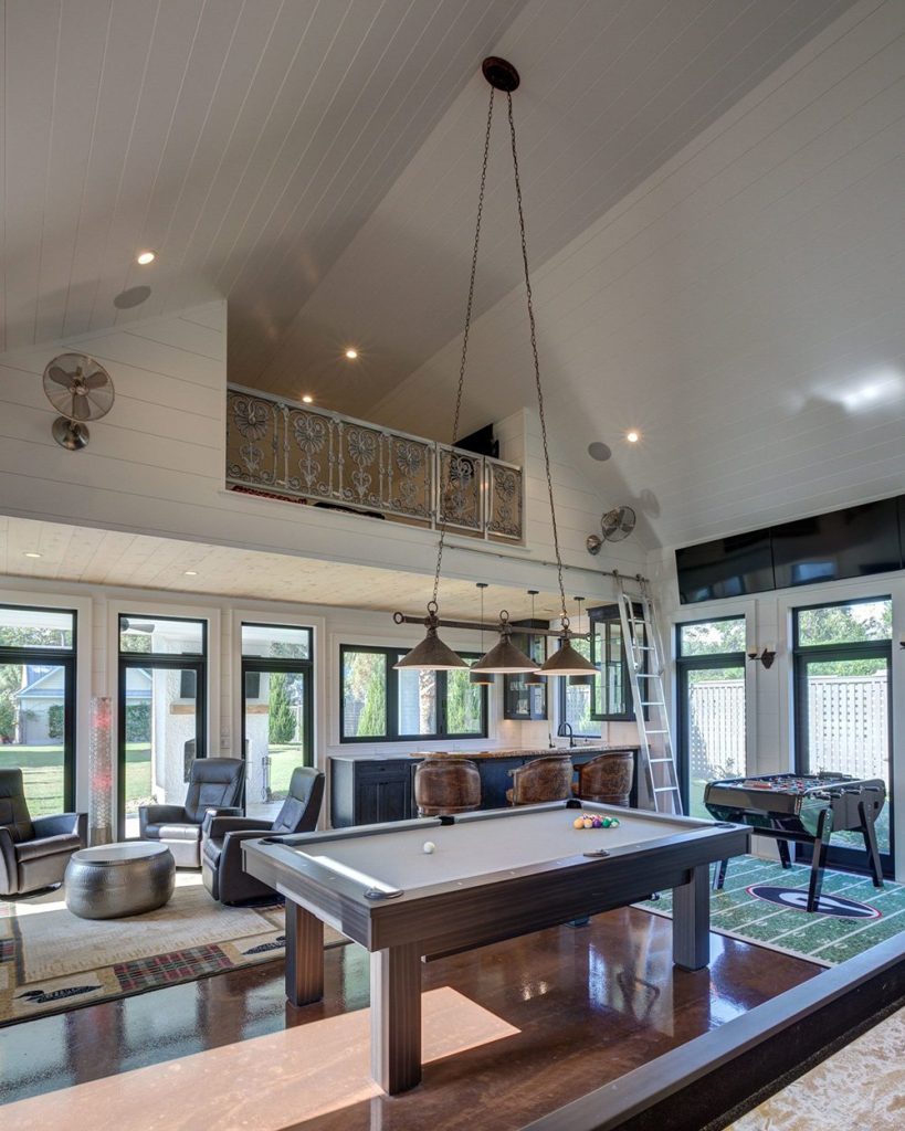 Debby Gomulka, luxury interior designer in Charleston, created a games room featuring a stylish pool table and foos ball table.