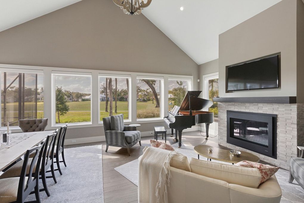 This stunning Florida interior design is modern and bright featuring a grand piano and living room space