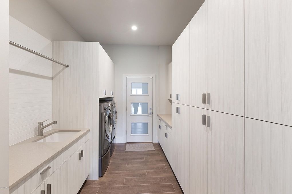 Florida interior design of modern laundry room with white cabinets.