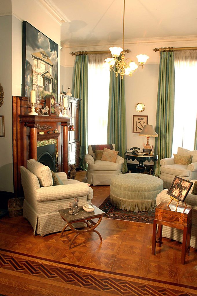 This historic preservation interior design includes antique furnishings and floor to ceiling drapery in eye-catching mint green.
