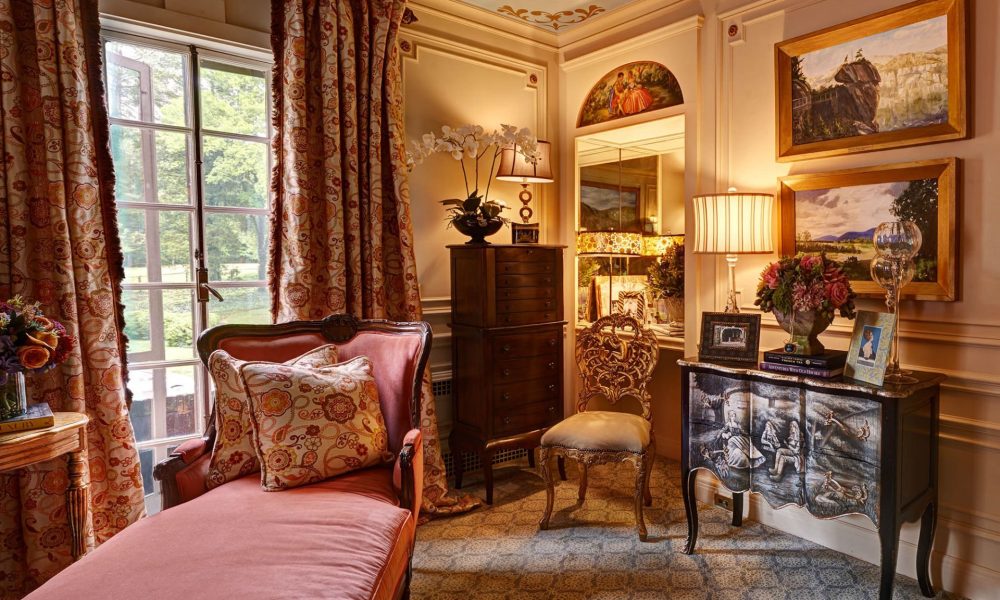 Antique furniture, rich fabrics and warm lighting create a cozy bedroom interior design in North Carolina